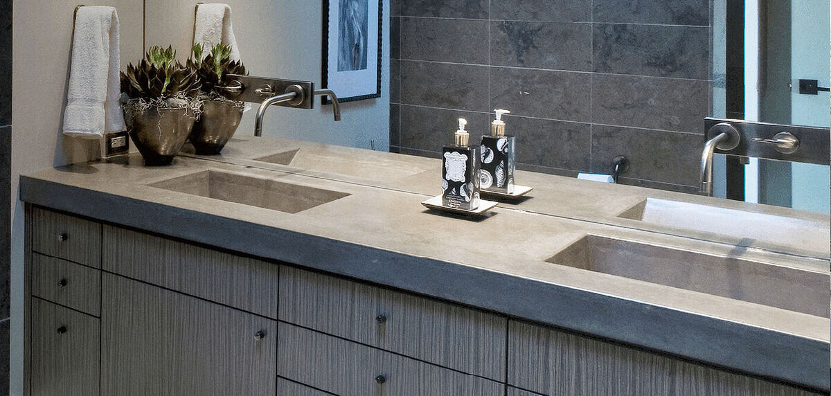 A bathroom vanity with twin basins and wall-mounted taps